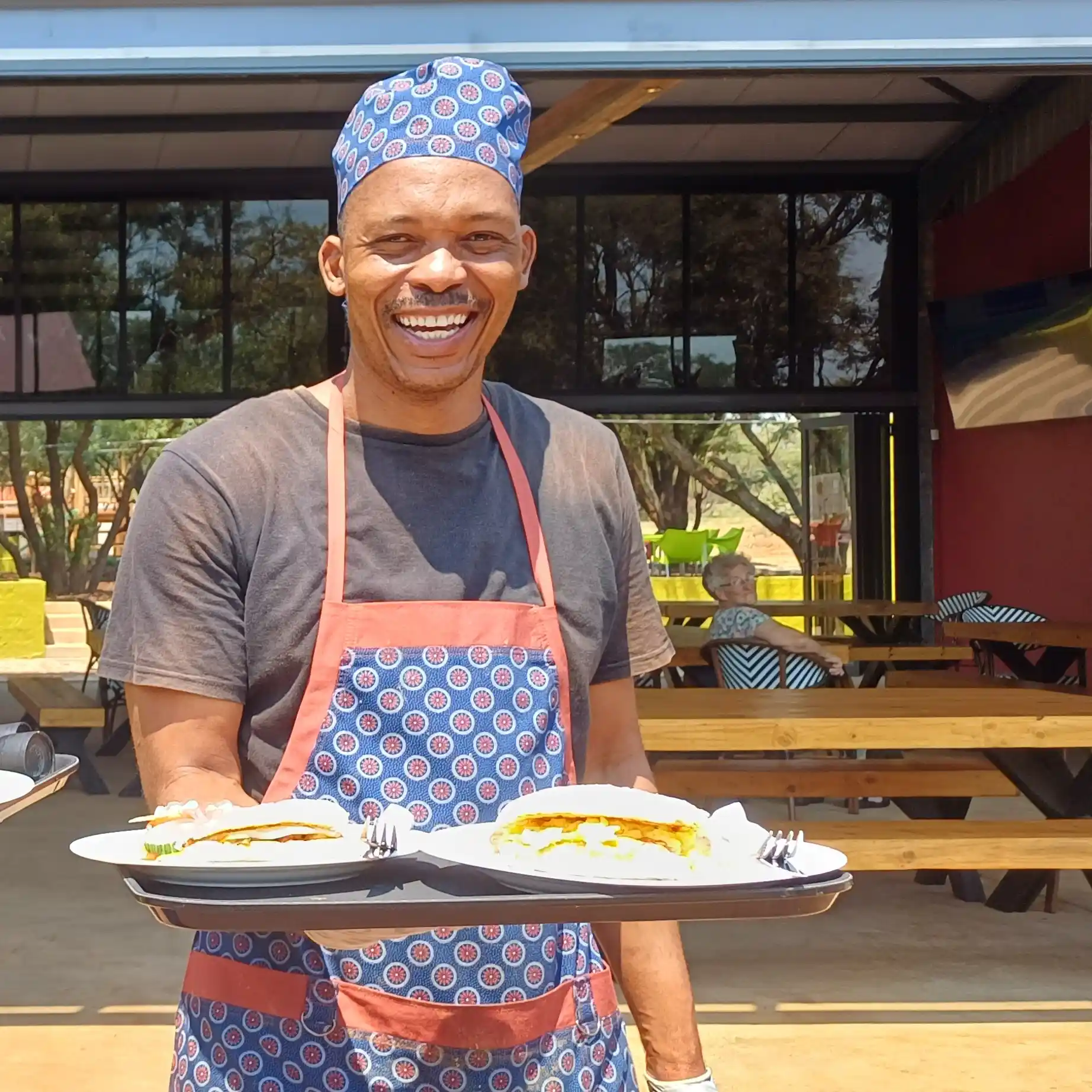 A waiter holds a plate of food outside the restaurant.