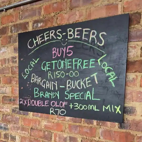 A blackboard showing the menu items for cocktails and beers.
